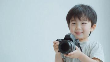Smiling boy with a camera on white background photo