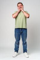 Happy middle-aged man showing joy while touching his face against a neutral background photo