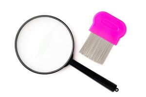 A magnifying glass and lice comb placed side by side on a clean white background photo