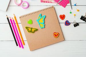 Crafting inspiration with colored pencils, decorative tape, and playful shapes on a rustic wooden surface photo