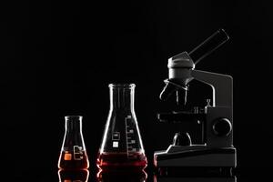 laboratory microscope on table in the dark photo