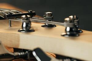Guitar headstock with tuners on dark background photo