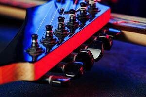 Guitar headstock with tuners on dark background photo
