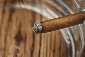 Lighted cigar in an ashtray close up photo
