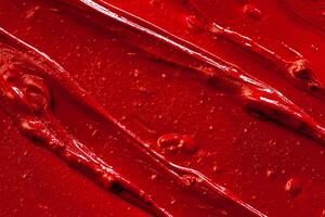 Red lipstick background texture smudged. Close up. photo