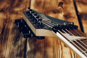 Guitar headstock with tuners on dark background photo