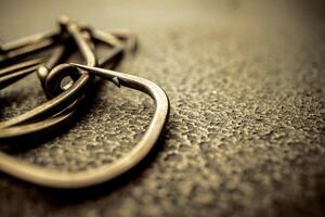 Fishing hooks on concrete textured background macro photo