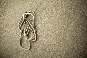 Fishing hooks on concrete textured background macro photo
