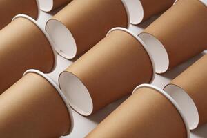 A collection of disposable paper cups arranged in a repeating pattern on a light background photo