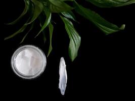 Natural organic face cream isolated on black with copy space. Cosmetics based on natural ingredients without preservatives. Concept of self-care and caring for the environment photo