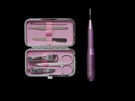 Pink manicure set isolated on black background with copy space photo