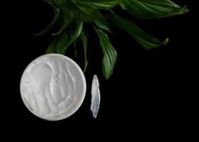 Natural organic body cream isolated on black with copy space. Cosmetics based on natural ingredients without preservatives. Concept of self-care and caring for the environment photo