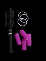 Different products for hair styling - comb, curlers and hair bands isolated on black background with copy space photo
