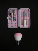 Pink manicure set isolated on black background with copy space photo