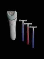 Different products for removing body hair - razor and epilator isolated on black background with copy space. Concept of choice and comparison photo