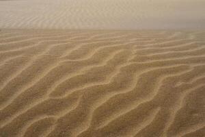 Sand textured pattern with copy space. Abstract background wallpaper. Sand waves in a desert dune photo