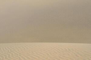Sand textured pattern with copy space. Abstract background wallpaper. Sand waves in a desert dune photo