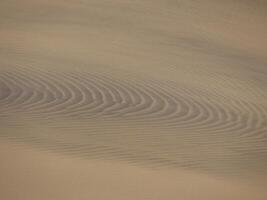Sand textured pattern with copy space. Abstract background wallpaper. Sand waves in a desert dune photo