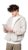 Young man using tablet device while wearing cozy jacket on transparent background png
