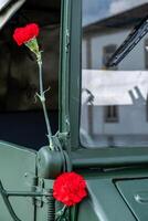 two red carnations decorating a military vehicle during the commemoration of April 25th in Portugal. Revolucao dos Cravos. photo