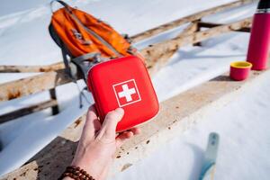 A person holds a red lifebuoy with a white cross on it photo