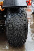 Closeup of ATV tire in rain, showing tread and synthetic rubber photo