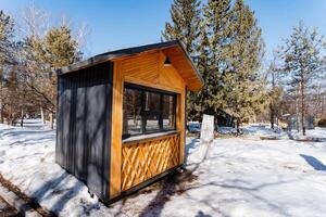 A cozy wooden cottage stands amid snowy trees in the forest photo