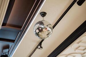A disco ball dangles from the hardwood ceiling of the room photo