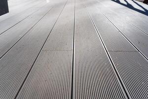 Closeup of grey hardwood flooring with diagonal pattern on wooden deck photo