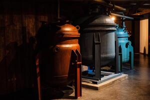 Two large metal tanks sit in a dark room next to each other photo