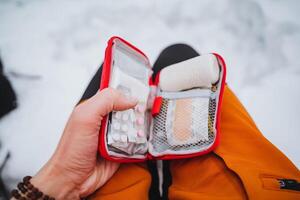 Emergency care with the use of a first aid kit, bushcraft in the winter forest, survival alone, pills for pain and nausea. Travel First Aid Kit. photo