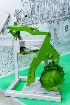 A green machine stands on a rectangular base on a grassy floor photo