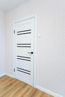 A white door with black stripes is a fixture in a room with a wooden floor photo
