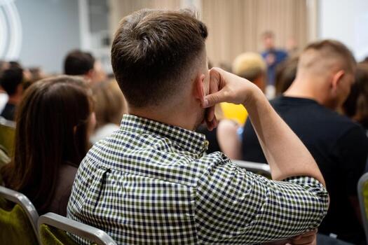 An engaged audience actively participating in a dynamic discussion during a conference, showcasing attentiveness and collaboration in their career photo