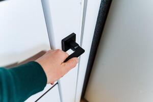 Using a sleek black handle, the person opens the door with a smooth gesture photo