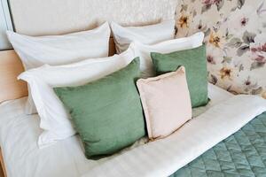 Rectangle bed with white linens, green and white pillow fashion accessories photo