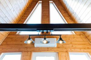 Wooden house with triangular ceiling and numerous windows for natural lighting photo