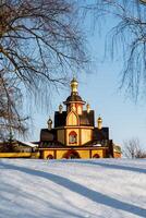 A church stands alone in a snowy field under a cold sky photo