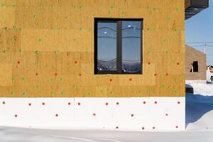 A house with a window and a wall covered in insulation photo
