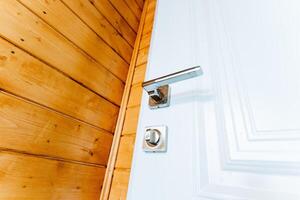 Close up of a wood door handle fixture on hardwood plank flooring photo