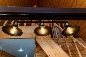 Wooden staircase with three hanging lights in kitchen photo