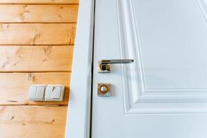 Closeup of a white door with a wooden wall in the background photo
