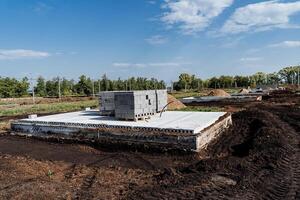 Currently, a strong foundation for a house is being constructed in a dirt field photo
