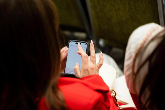 An engaged participant is actively texting on their smartphone while in a conference setting, showcasing their connection and communication photo