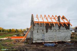 A house is currently being constructed using wooden beams for the roof photo