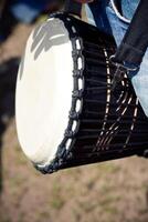 Person with a hand drum strapped around their shoulder photo