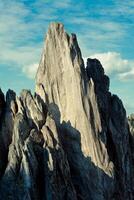 a large rocky mountain with a blue sky in the background photo