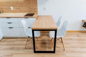 A kitchen table with two chairs and a wooden table photo