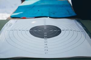 A target with numbers sits on a table covered with a tarpaulin under a hood photo