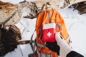 First Aid Kit in the Snow for Emergencies While Backpacking in the Wilderness photo